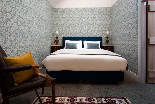 a bedroom with a large bed and a chair at Ploughman's Bothy at Papple Steading in East Linton