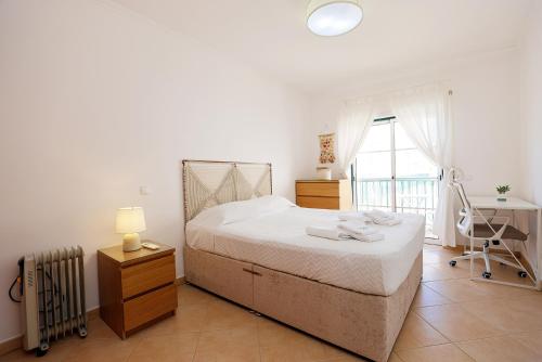 1 dormitorio con cama, escritorio y ventana en B95 - Casa Melo Apartment in Praia da Luz, en Luz