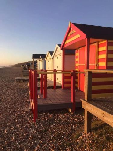 a row of colorful beach huts on the beach at Central Village flat, close to beach in Milford on Sea