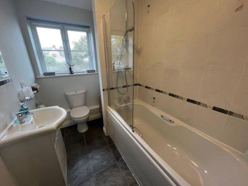y baño con aseo, bañera y lavamanos. en Central Village flat, close to beach, en Milford on Sea