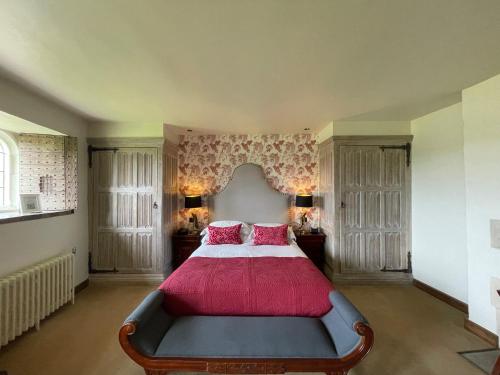 a bedroom with a large bed with red pillows at Leeds Castle Maiden's Tower in Maidstone