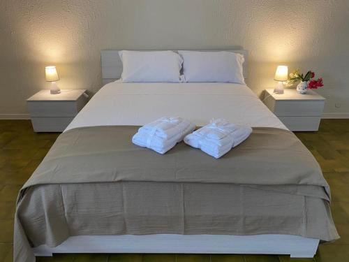 a large white bed with two towels on it at Green House Trecastagni in Trecastagni