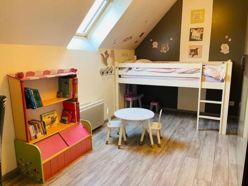 a small room with two bunk beds and a table at Maison chaleureuse centre Saran in Saran