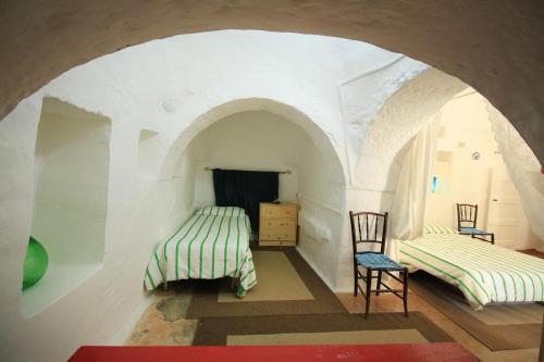 een kamer met 2 bedden en een tafel en stoelen bij Estate nel trullo in Villa Castelli