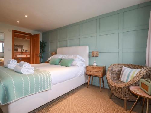a bedroom with a white bed and a chair at Sea View House in Newquay