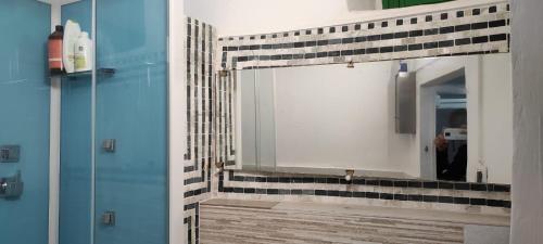 een badkamer met een spiegel met zwarte en witte tegels bij Estate nel trullo in Villa Castelli