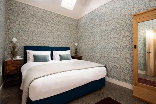 a bedroom with a large bed with a blue headboard at Shepherd's Bothy at Papple Steading in East Linton