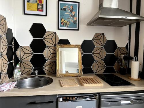 - un comptoir de cuisine avec un évier et un miroir dans l'établissement L'Atypique d'Orléans, à Orléans