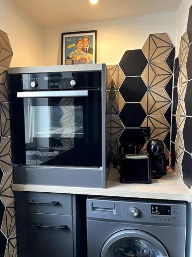 une cuisine avec un micro-ondes et un lave-linge dans l'établissement L'Atypique d'Orléans, à Orléans