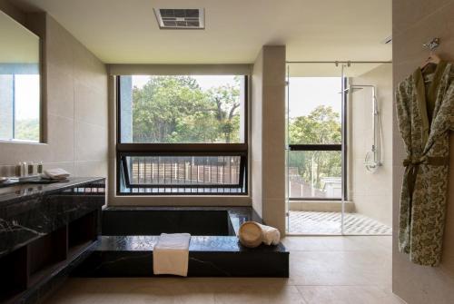 a bathroom with a large window and a shower at Fuli Hot Spring Resort in Yuchi