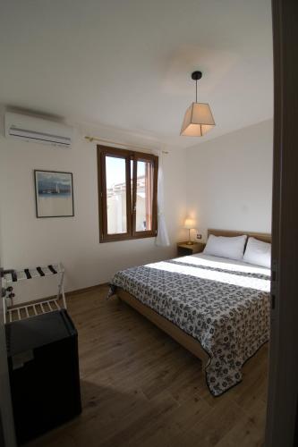 a bedroom with a large bed and a window at Dommu Livia in Lotzorai