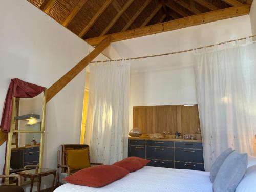 a bedroom with a bed and a kitchen at Casa Beleza do Sul in Tavira