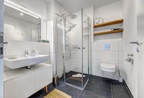 a bathroom with a shower and a sink and a toilet at Ferienhaus "Süsterhüs" - Seeluft und Komfort in Loddin