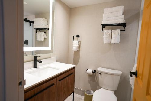 a bathroom with a sink and a toilet and a mirror at The Boulevard Hotel in Beach Haven Gardens