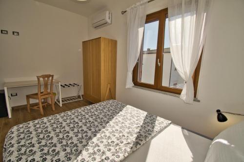 um quarto com uma cama e uma janela em Dommu Livia em Lotzorai