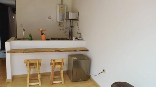 uma cozinha com dois bancos de madeira e um balcão em UE Home 203 em Duitama