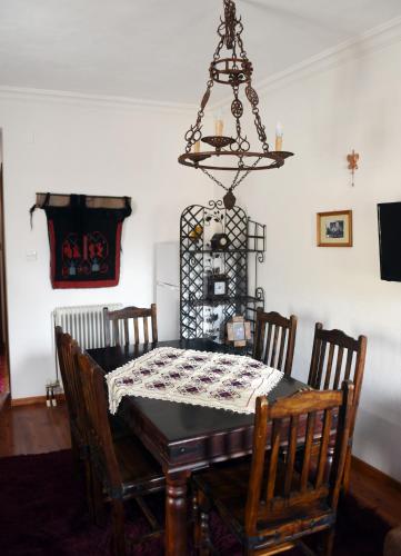 a dining room with a table and a chandelier at ΛΑΓΟΥΜΙ suite Α1 in Elati Trikalon
