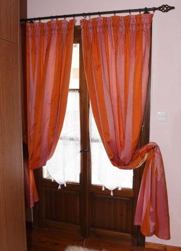 a window with orange curtains in a room at ΛΑΓΟΥΜΙ suite Α1 in Elati Trikalon