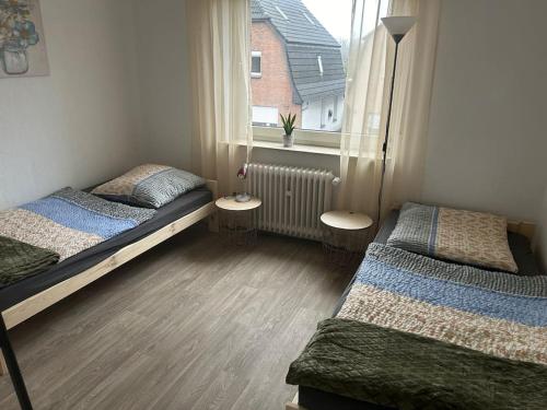 - une chambre avec 2 lits et une fenêtre dans l'établissement Gästehaus Aarninkstraße, à Nordhorn
