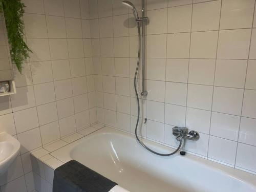 a bath tub with a shower in a bathroom at Gästehaus Aarninkstraße in Nordhorn