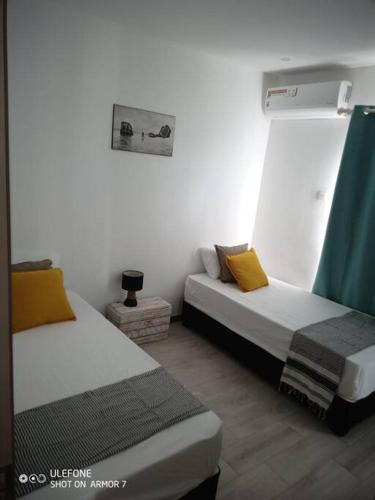 a room with two beds in a room at Kensington square in Flic-en-Flac