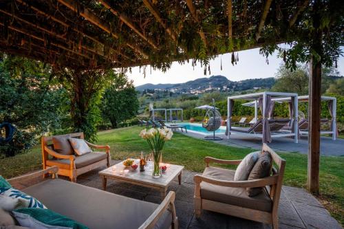 a patio with chairs and a table and a pool at Casa Lucchese al Borghetto in Collodi
