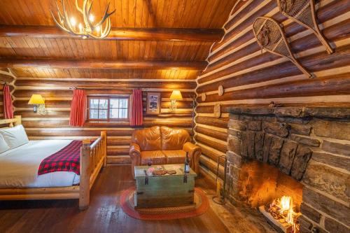 Storm Mountain Lodge & Cabins في بانف: غرفة نوم مع موقد في كابينة خشب