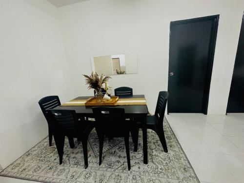 a dining room table with black chairs and a mirror at Adamhawa Homestay Emerald Avenue Brinchang in Brinchang