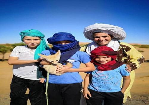 a group of people wearing turbans and holding a cat at Desert Luxury Tented & Activities in Hassilabied