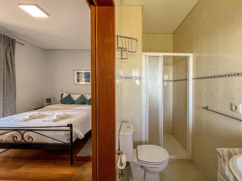 y baño con cama, ducha y aseo. en Lovely Sunny-House, en Viana do Castelo