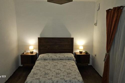 a bedroom with a bed and two lamps on two tables at Apartamento Candombe in Montevideo