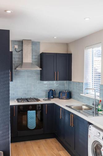 a kitchen with blue cabinets and a sink at 68 Glenwood Road in Ellesmere Port