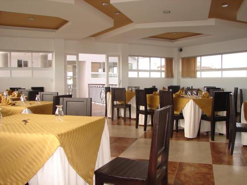 uma sala de jantar com mesas e cadeiras com toalha de mesa amarela em Hotel San Jeronimo em Popayán