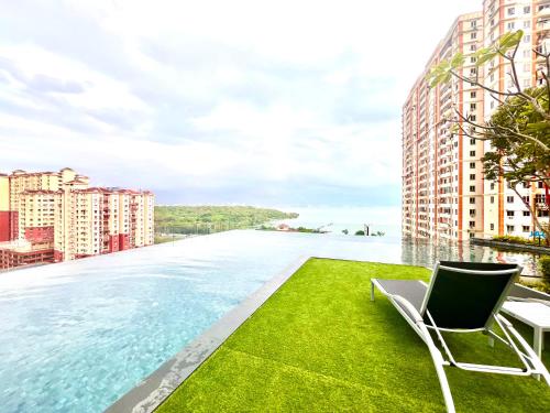 una piscina con sillas y vistas al agua en Urban Suites Jelutong Georgetown, en Jelutong