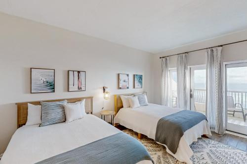 two beds in a bedroom with a view of the ocean at 306 Sandcastles in Fernandina Beach