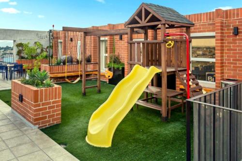 a playground with a slide and a play house at Nuevo y Moderno Apartamento con Parqueo en la atractiva Zona 4 in Guatemala