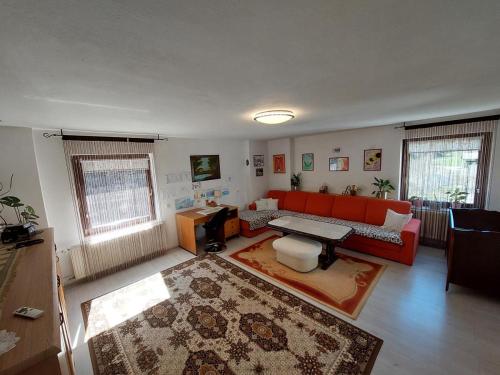 a living room with a red couch and a rug at Tiha dolina in Železniki