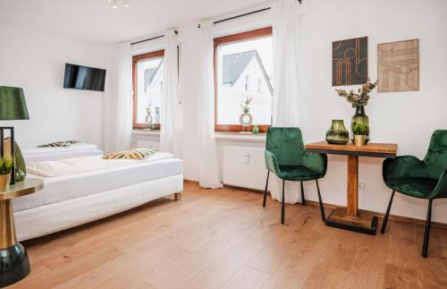 um quarto com uma cama, uma mesa e cadeiras em Kurzzeitglück 24h Self Check-In MH02 em Mülheim an der Ruhr