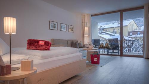 una camera da letto con un letto e un soggiorno di Il Tyrol a San Candido