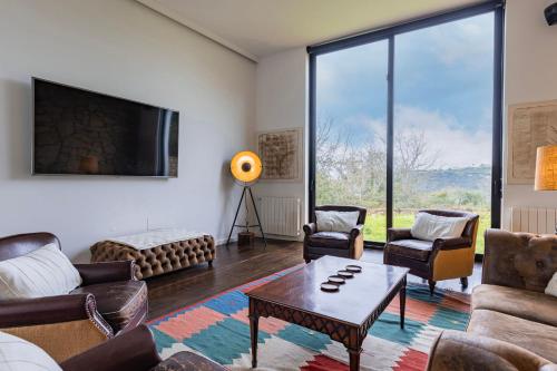 sala de estar con sofás, TV y mesa en Quinta Casal dos Coxos by LovelyStay, en Sobral de Monte Agraço