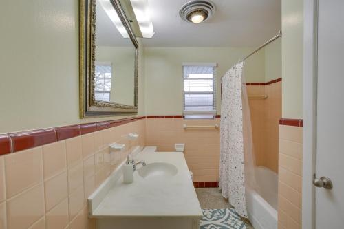 a bathroom with a sink and a mirror and a tub at New Orleans Area Home Near the Lake and City Park! in Metairie