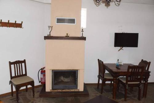 - un salon avec une cheminée, une table et des chaises dans l'établissement ΛΑΓΟΥΜΙ suite Α3, à Elati