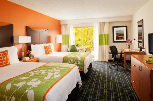 a hotel room with two beds and a desk at The Querque Hotel in Albuquerque