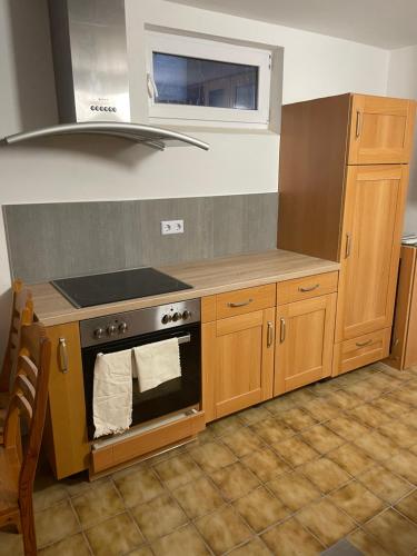 a kitchen with wooden cabinets and a stove at Wohnung für Firmen, Arbeiter ab 6 Monaten bis Unbefristet in Linsengericht