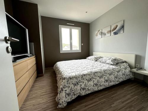 um quarto com uma cama e uma televisão de ecrã plano em Accès direct plage 100m em Jullouville-les-Pins