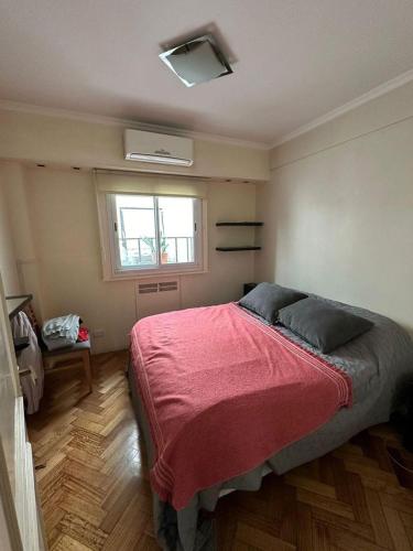 - une chambre avec un grand lit et une couverture rouge dans l'établissement Pleno Recoleta, à Buenos Aires