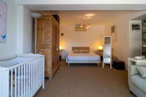 a bedroom with a bed and a tub and a crib at Rosa - Sublime villa piscine avec vue et pinèdes in Saint-Georges-dʼOrques