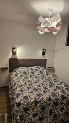 een slaapkamer met een bed met een zwart-witte deken bij Le Cosy - joliment aménagé - vue magnifique in Sévrier
