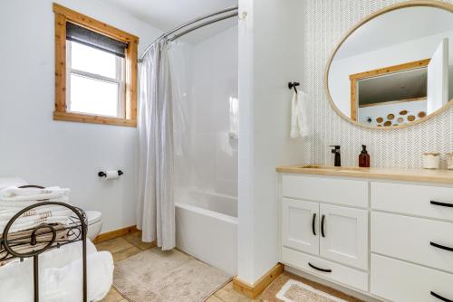 ein Badezimmer mit einer Badewanne, einem Waschbecken und einem Spiegel in der Unterkunft Bright Shipshewana Gem with Shuffleboard Table! in Shipshewana