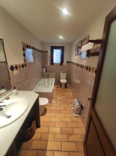 a bathroom with a sink and a toilet and a tub at La Kamareta de Chite in Granada
